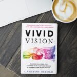 The book "Vivid Vision" by Cameron Herold sitting on a desk.